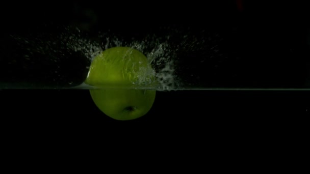 Green apple plunging into water — Stock Video