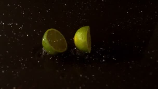 Lime halves dropping on wet surface — Stock Video