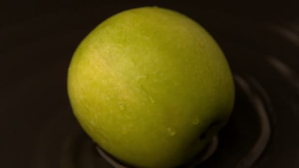 Pomme verte filant sur surface humide — Video