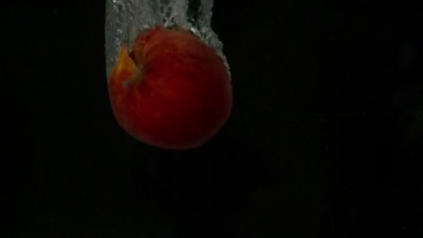 Червоне яблуко занурюється у воду — стокове відео