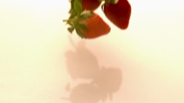 Strawberries falling on wet surface — Stock Video