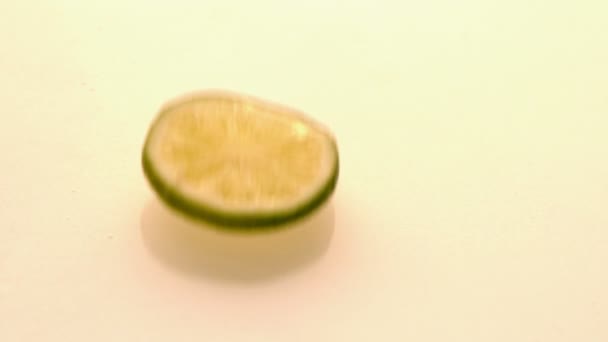 Rondelle de citron vert chute sur sol mouillé — Stock video