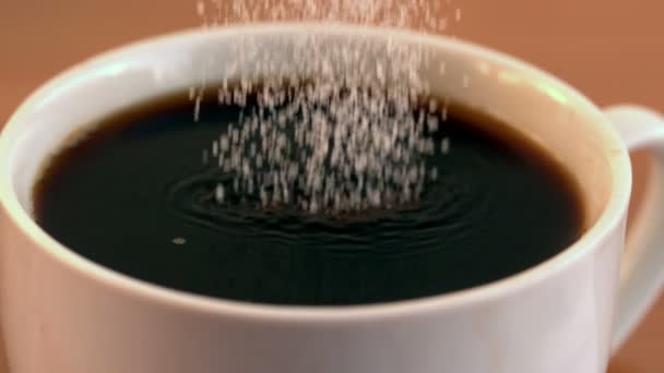 Сахар наливается в чашку кофе — стоковое видео