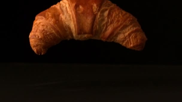 Croissant falling onto black surface — Stock Video