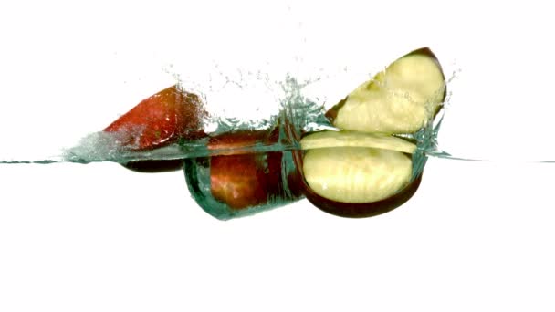 Segmentos de manzana sumergiéndose en el agua — Vídeos de Stock