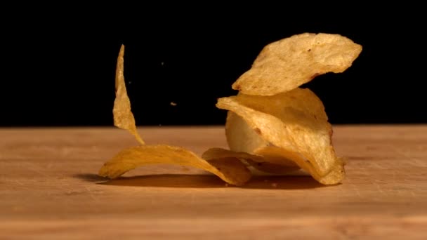 Chips cayendo sobre mesa de madera — Vídeos de Stock