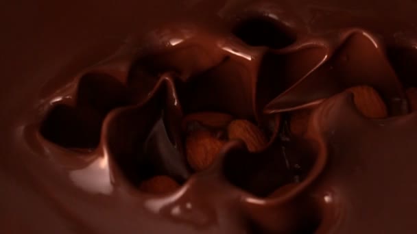 Amandelen vallen in gesmolten chocolade — Stockvideo
