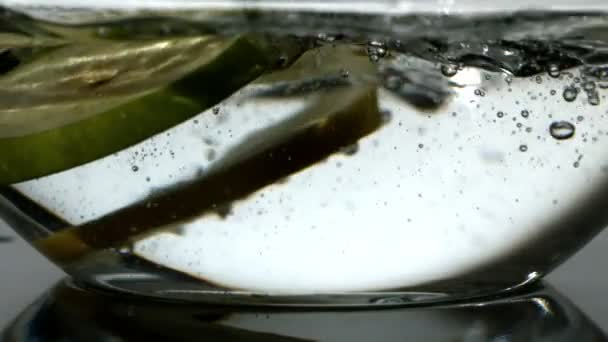 Fruit plakjes vallen in kom met water — Stockvideo