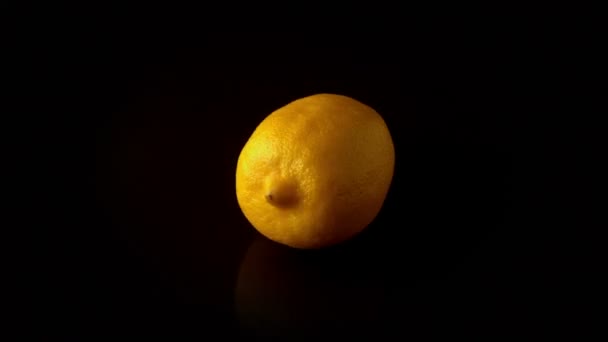 Lemon spinning on black surface — Stock Video