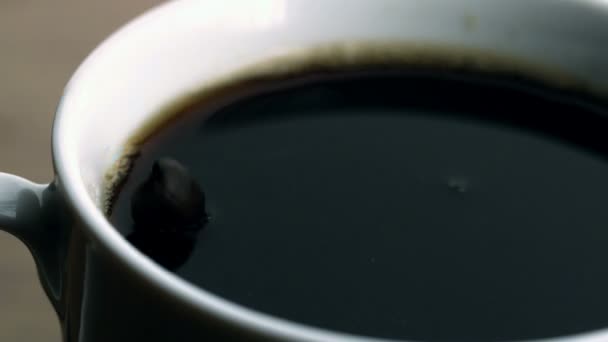 Beans falling into cup of coffee — Stock Video