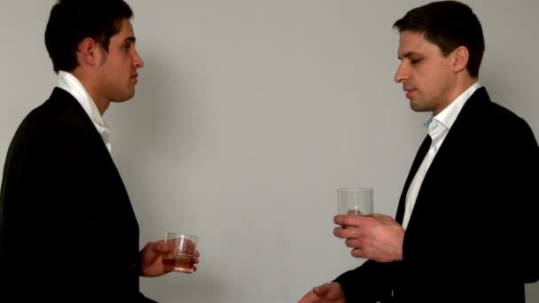 Мужчины пьют виски пожимая руки — стоковое видео