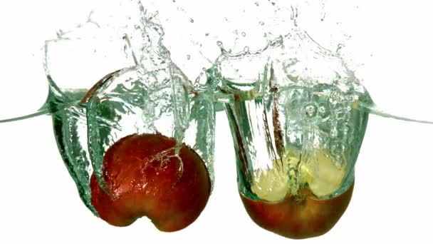 Apple halves plunging into water — Stock Video