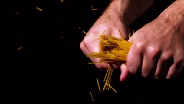 Manos rompiendo espaguetis por la mitad — Vídeo de stock
