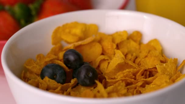 Arándanos vertiendo en un tazón de cereales — Vídeo de stock