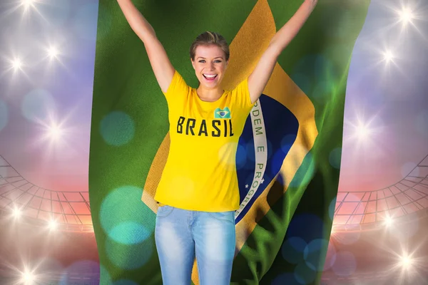 Возбужденный футбольный фанат в бразильской футболке холдинг — стоковое фото
