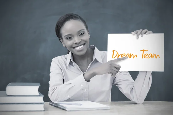 Happy teacher holding page showing dream team — Stock Photo, Image