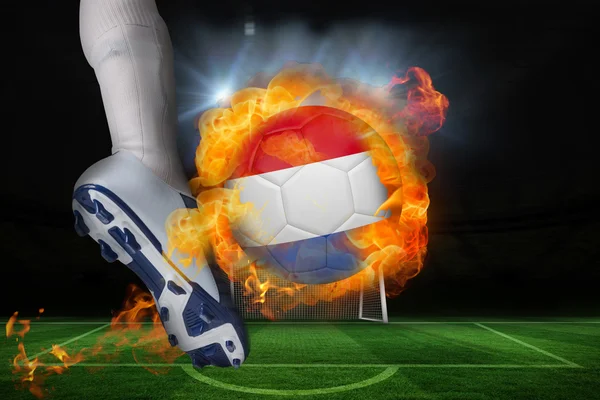 Football player kicking flaming netherlands flag ball — Stock Photo, Image