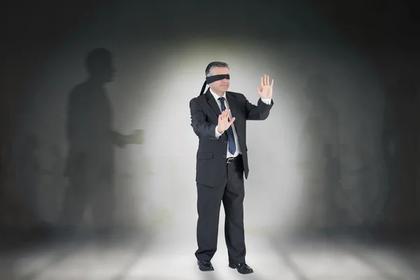 Composite image of mature businessman in a blindfold — Stock Photo, Image