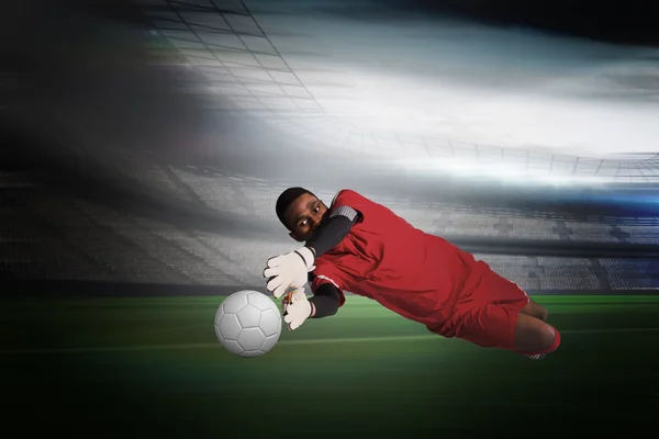 Composite image of goalkeeper in red making a save — Stock Photo, Image