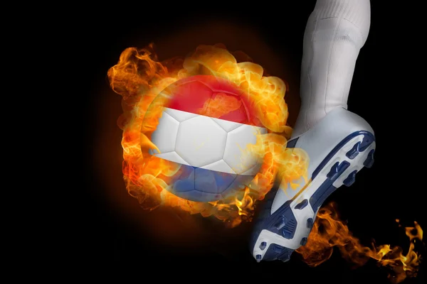 Football player kicking flaming netherlands ball — Stock Photo, Image