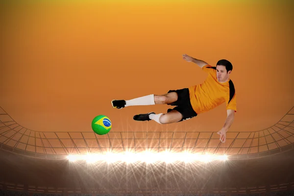 Composite image of football player in orange jumping — Stock Photo, Image