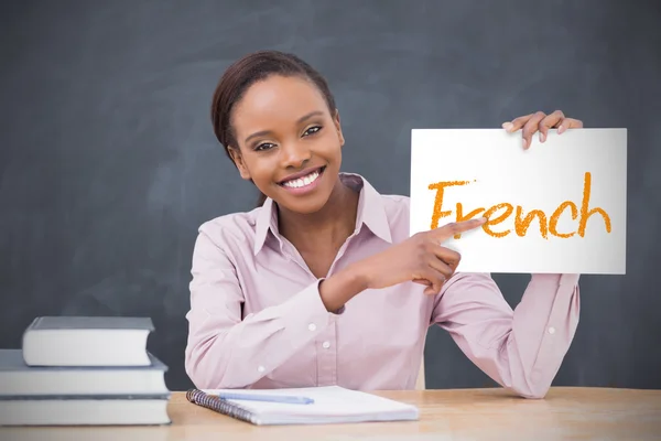 Happy teacher holding page showing french — Stock Photo, Image