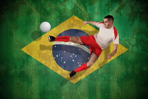 Composite image of fit football player playing and kicking — Stock Photo, Image