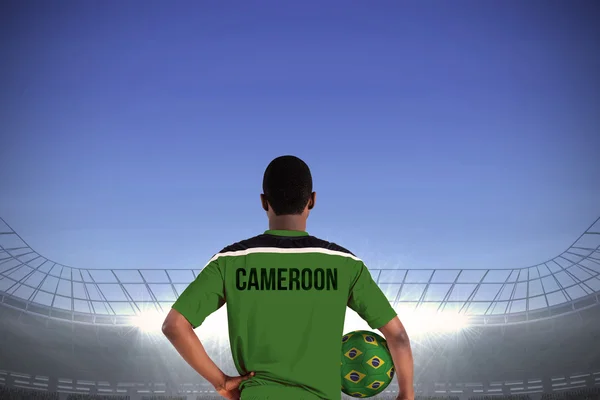 Imagen compuesta del jugador de fútbol camerún sosteniendo la pelota — Foto de Stock