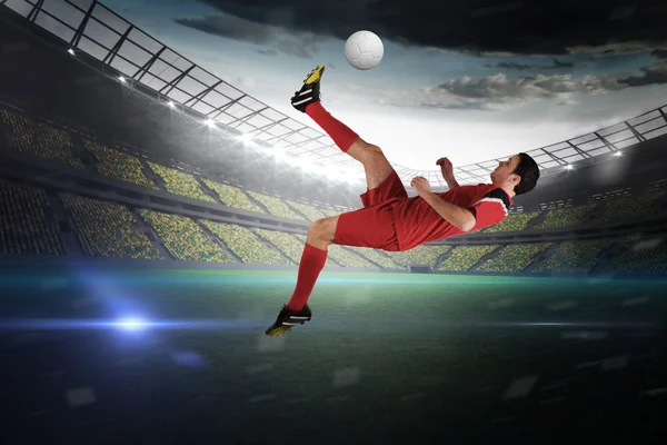 Imagen compuesta de jugador de fútbol en rojo patadas — Foto de Stock