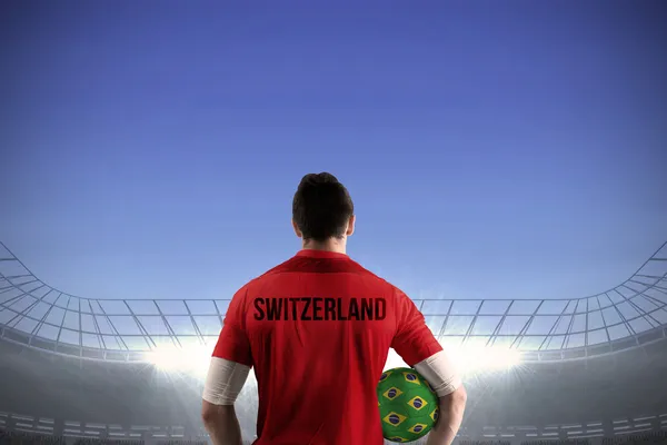 Sammansatt bild av schweizisk fotbollsspelare hålla bollen — Stockfoto