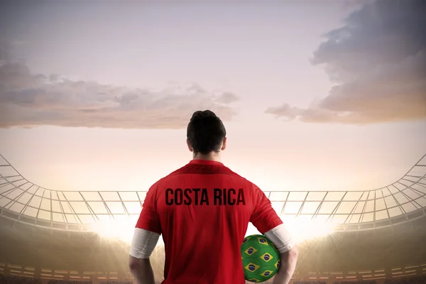 Imagen compuesta del futbolista costarricense sosteniendo pelota — Foto de Stock