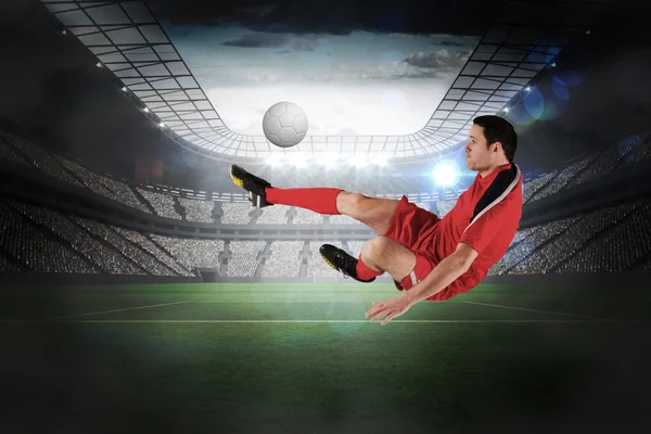 Imagem composta de jogador de futebol em chute vermelho — Fotografia de Stock