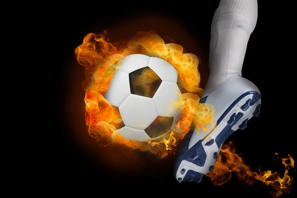 Football player kicking flaming ball — Stock Photo, Image