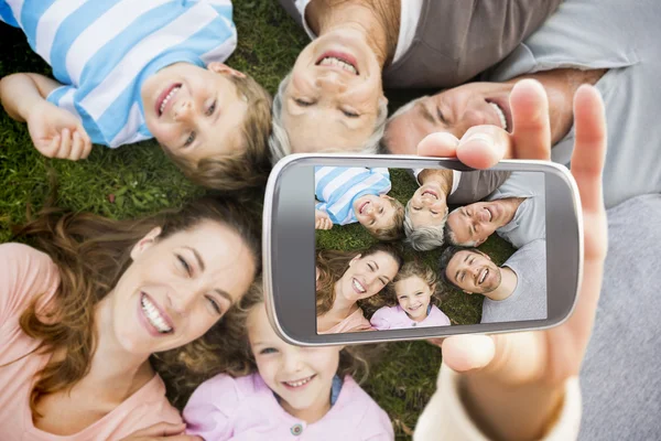 Hand holding smartphone showing family — Stock Photo, Image