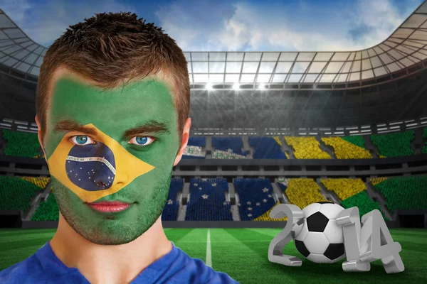 Bileşik görüntü ciddi genç brasil fan ile yüz boyama — Stok fotoğraf