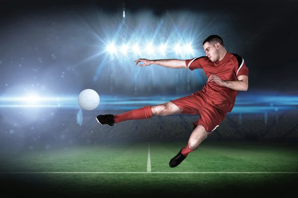 Imagen compuesta del jugador de fútbol en forma jugando y pateando — Foto de Stock