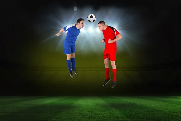 Composite image of football players tackling for the ball — Stock Photo, Image