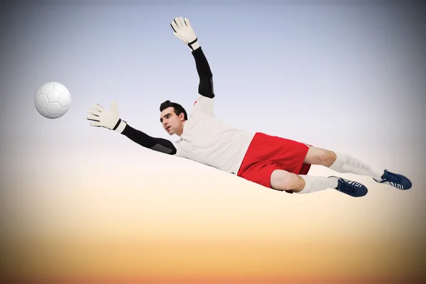 Composite image of goalkeeper in white making a save — Stock Photo, Image