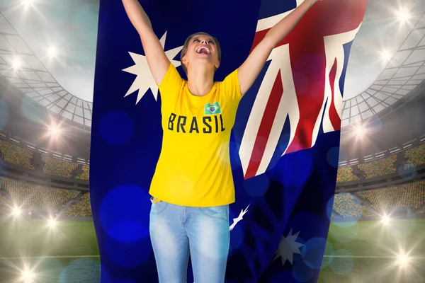 Excited football fan in brasil tshirt holding flag — Stock Photo, Image