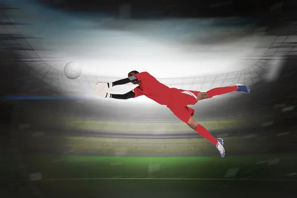 Composite image of goalkeeper in red making a save — Stock Photo, Image