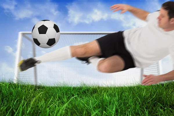 Jogador de futebol em branco chutando bola — Fotografia de Stock