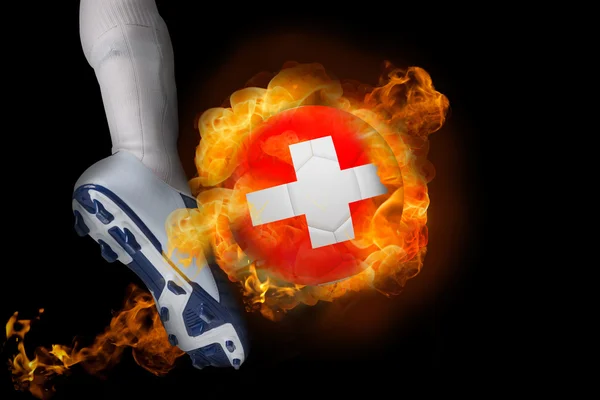 Футболист пинает огненный швейцарский мяч — стоковое фото