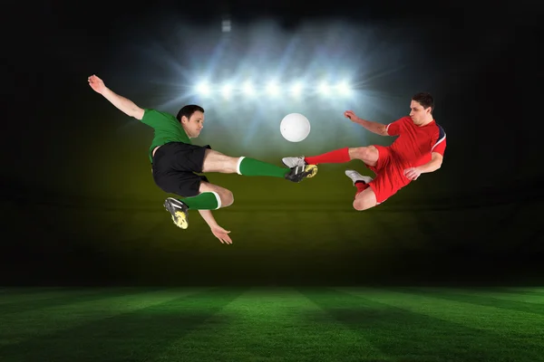 Composite image of football players tackling for the ball — Stock Photo, Image