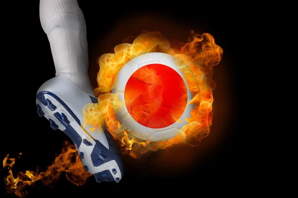 Football player kicking flaming japan ball — Stock Photo, Image