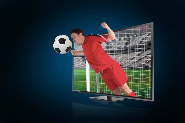 Imagen compuesta del jugador de fútbol en la bola roja de la partida a través de t — Foto de Stock