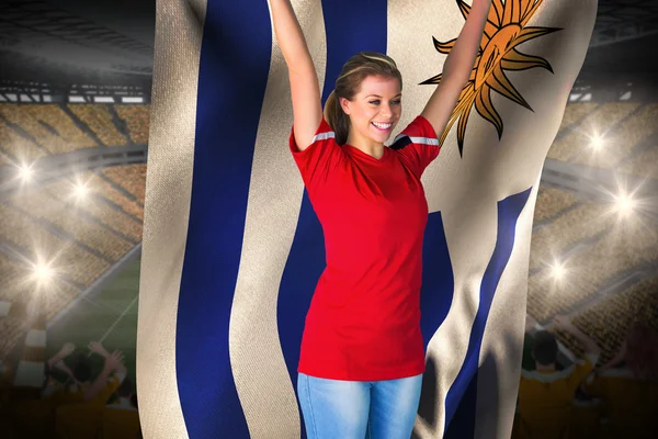 Abanico animador de fútbol en rojo sosteniendo bandera uruguay — Foto de Stock
