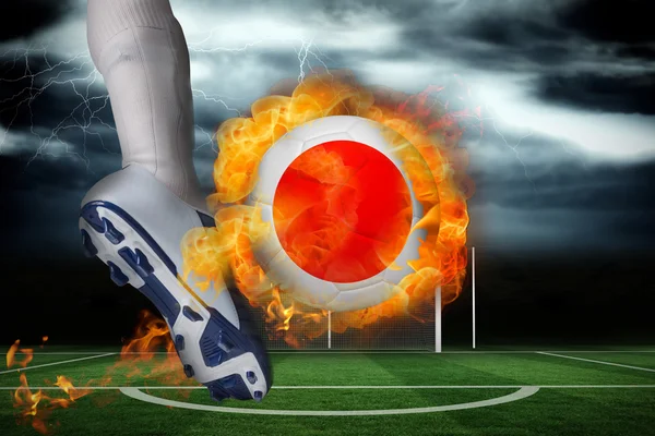 Football player kicking flaming japan flag ball — Stock Photo, Image