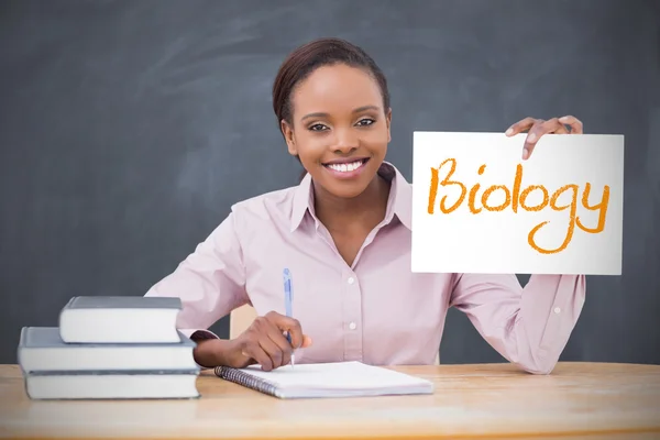 Happy teacher holding page showing biology — Stock Photo, Image