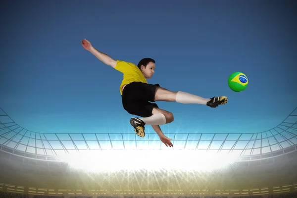 Composite image of football player in yellow kicking — Stock Photo, Image