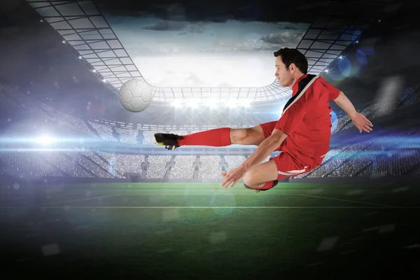 Composite image of football player in red kicking — Stock Photo, Image